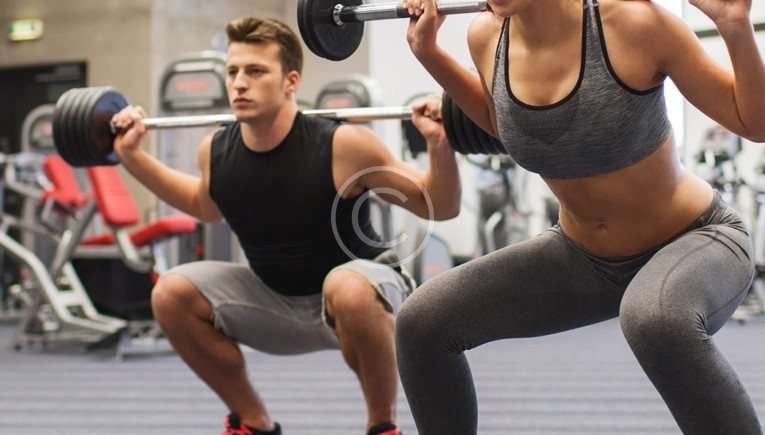 Guy Girl Squatting With Weights